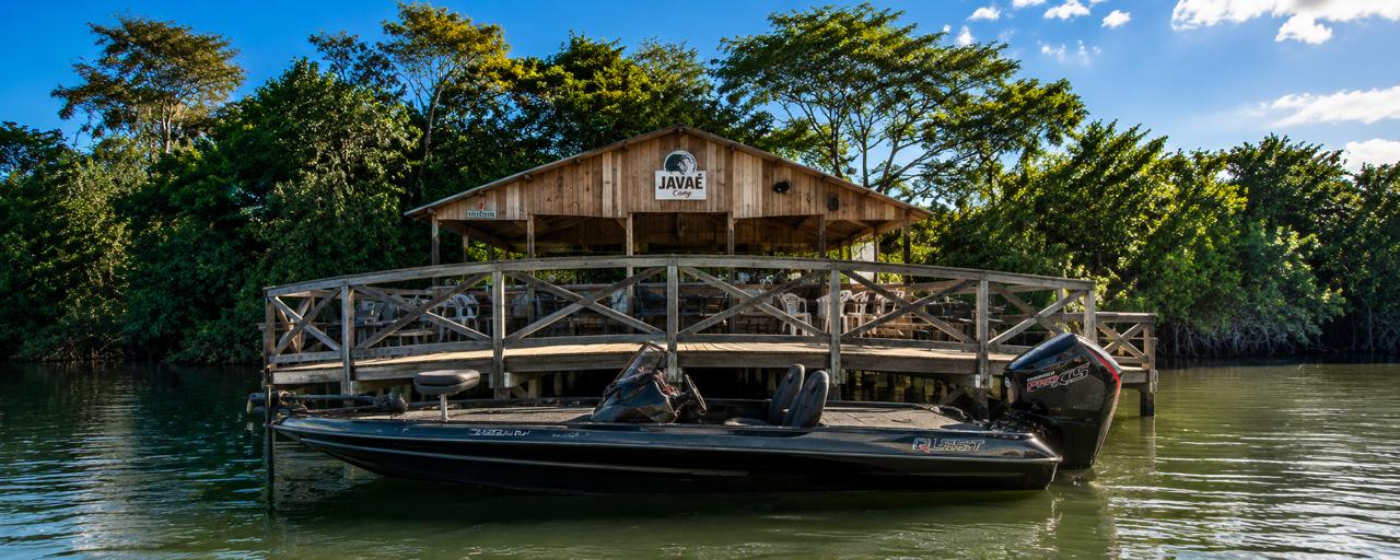 Água, barco e vegetação diante do Javaé Camp